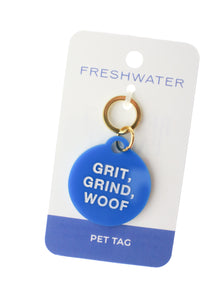 blue circle dog tag with white lettering saying grit grind woof on white background
