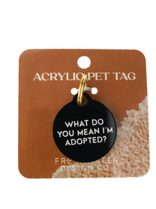 black circle dog tag with white lettering on terracotta paper and white background