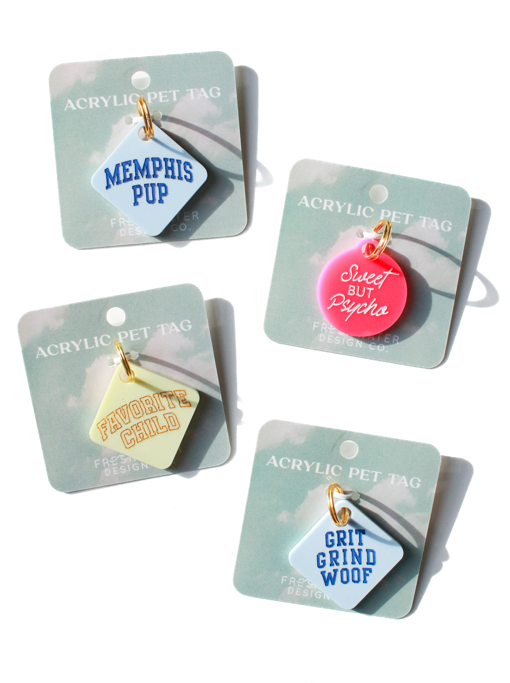 multiple acrylic dog tags on paper backings and a white backdrop