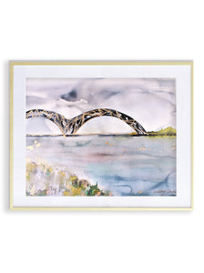 A framed artwork print depicting a bridge over water with a white border and metallic gold accents, displayed in a landscape orientation.